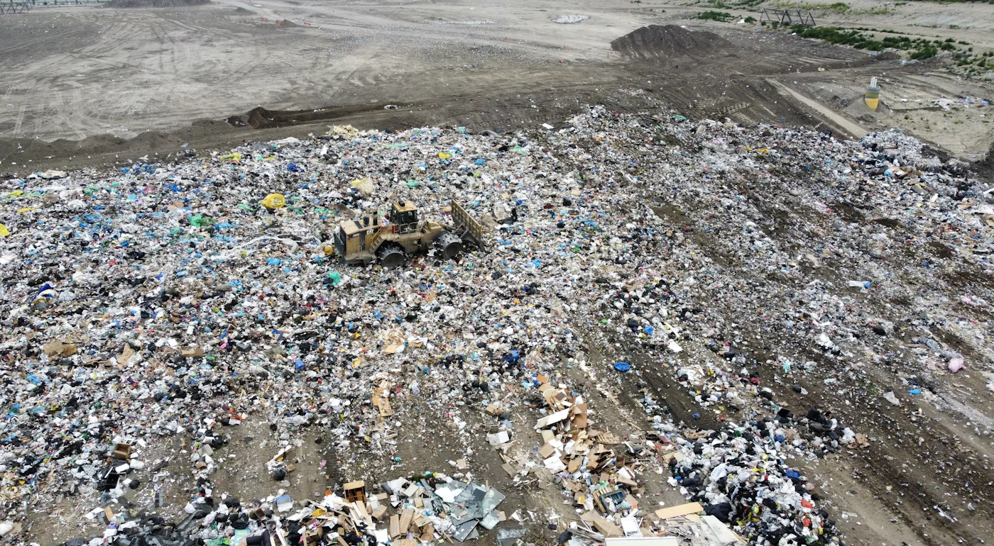 Bulldozer compacting waste on a large landfill